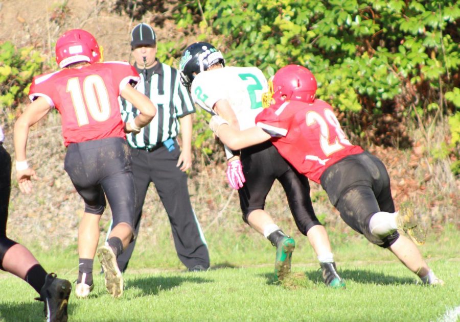 In this 2019 photo, Cauy Jackson (28) tackles Riddles Justin Jenks (2) while Keith Gaskell assists. Once rivals, now all three are teammates because of the schools co-op.