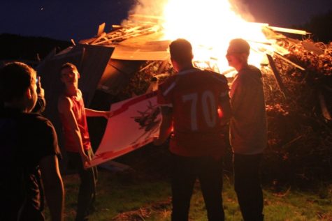Students throw a banner into a bonfire in 2019.