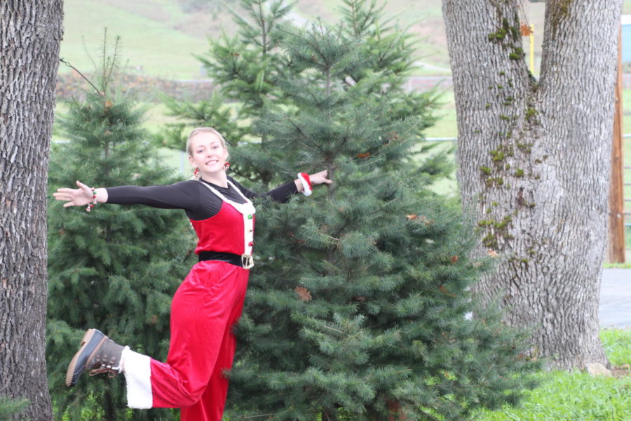 Junior Bailey Stufflebeam poses next to a fir tree grown years ago as an FFA project. Trees can be purchased.