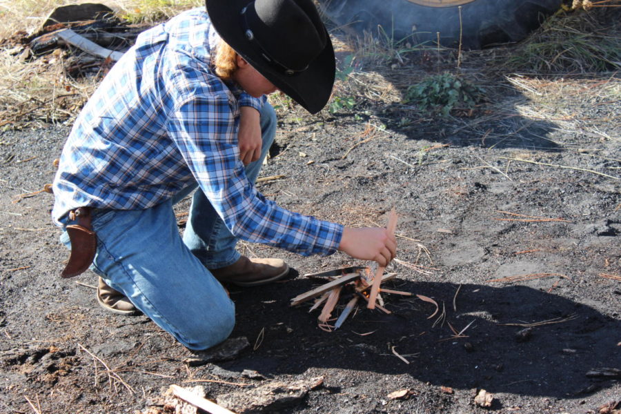 Junior Ian Harding builds a fire on Oct. 25 at Mr. Giles property near Milo as part of Homesteading class. 