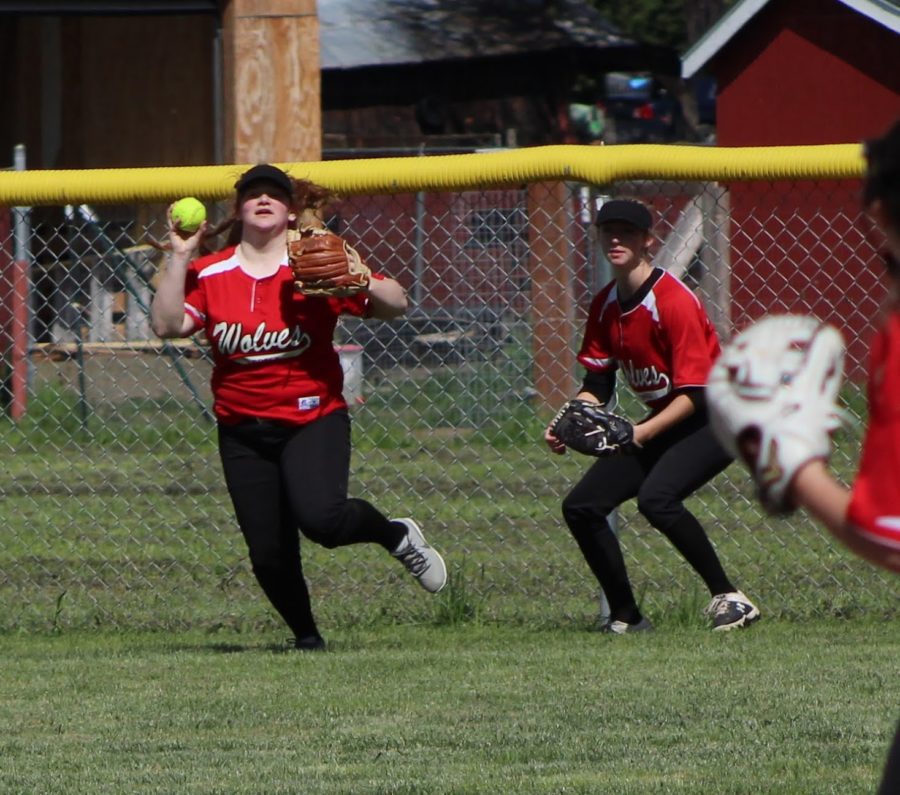 Junior Kaleigh Loiodici, left, relays the ball back into the infield after making an out during a game against Oakland last spring while teammate Riley Crume backs up the play. Both return for the Wolves this season and participated in a preseason camp for pitchers and catchers.