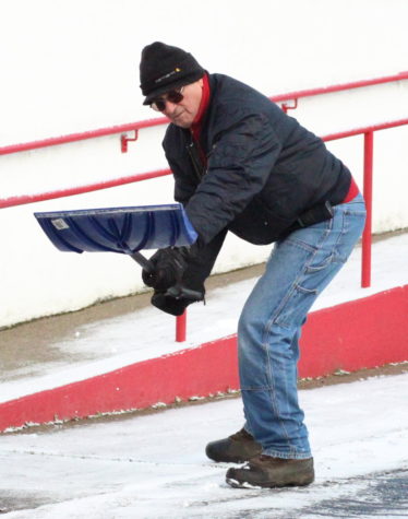 Maintenance worker Vince Hernandez scoops snow off the elementary ramp on Feb. 22 before the start of school.