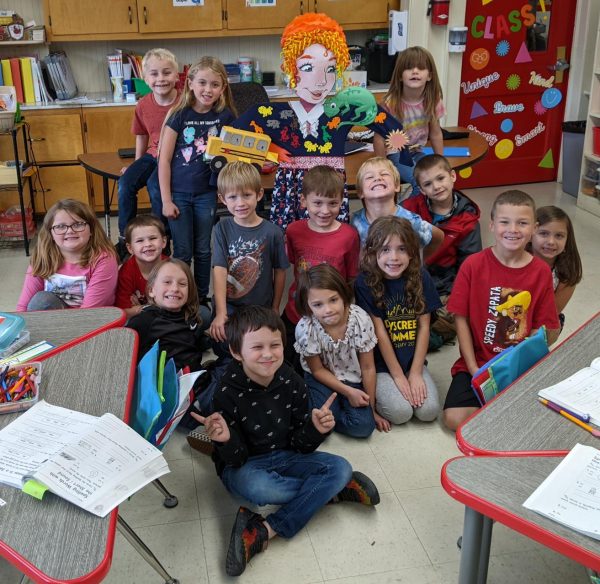 First grade students pose with their Ms. Frizzle scarecrow. The students entered their scarecrow into a Canyonville Library contest and won a pizza party.