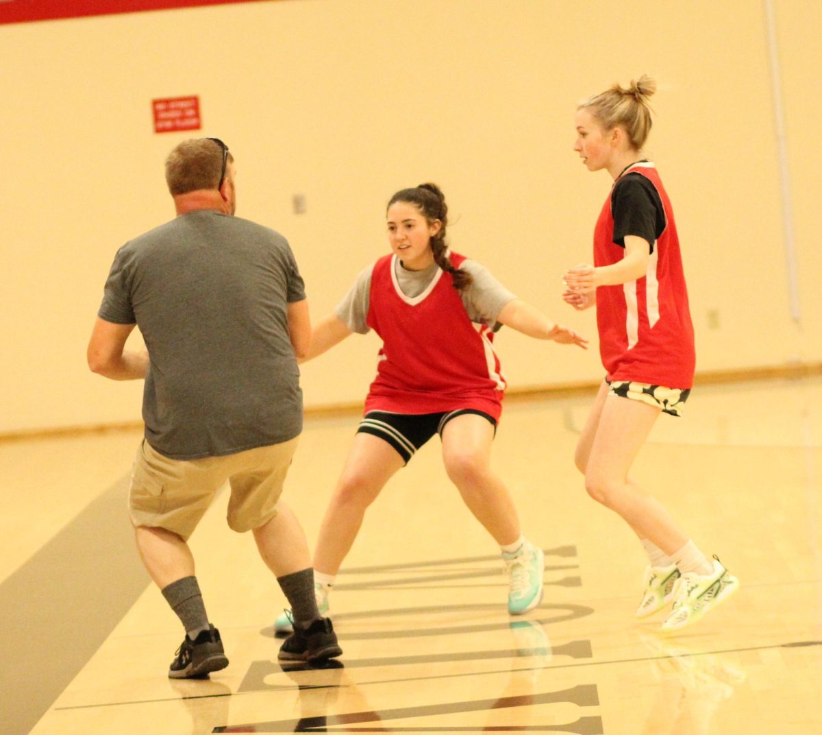 Seniors Natalie Harris, middle, and Shayleigh Lynn go through a drill with coach Matt Crume Tuesday in the Days Creek gym. 