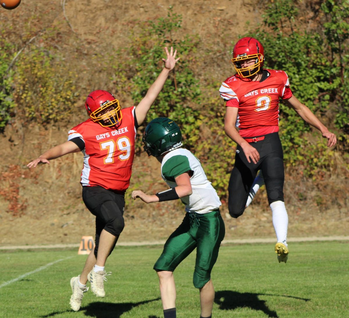 Seniors Isaiah Sprague (79) and Keegan Stufflebeam (9) rush a Gilchrist quarterback during a game last October. Both players were selected to play in the 6-man all-star game in La Grande on June 20.
