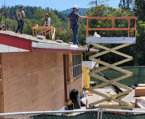 Construction crews from Ausland Construction work on the Days Creek gymnasium roof Tuesday afternoon. The school was awarded a $2.4 million seismic grant.