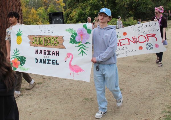 Xane Hopkins, left, and Jaron Cargill carry the class banner as juniors last years for homecoming. 