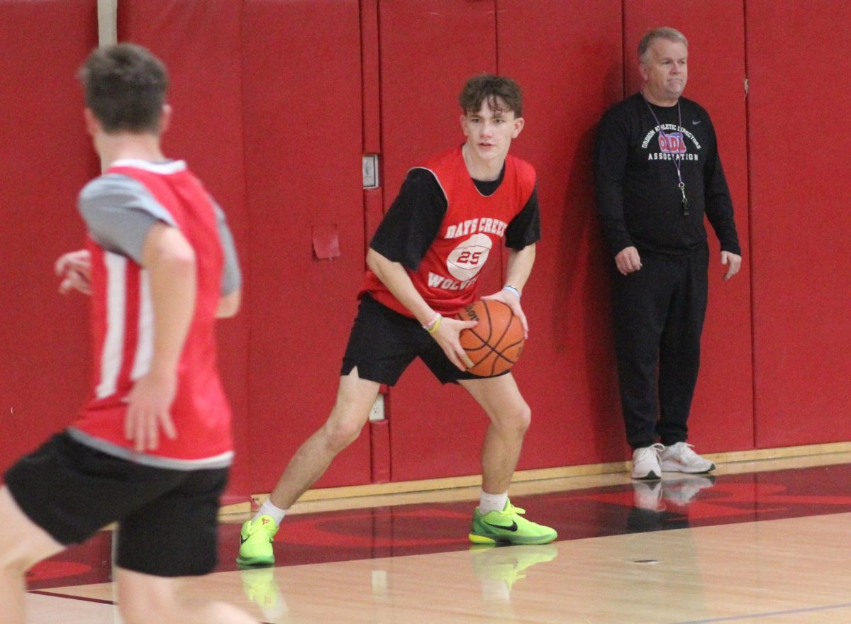 Sophomore Joe Young, middle, goes through a passing drill with Ty Sawyer while coach James Ellis watches last week. The Wolves open their season Wednesday at home against Mohawk.
