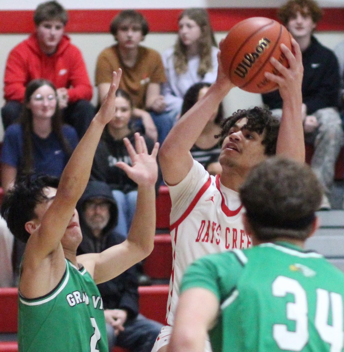 Xane Hopkins shoots over Grandview Christian defenders during a first round state playoff game at home. 
